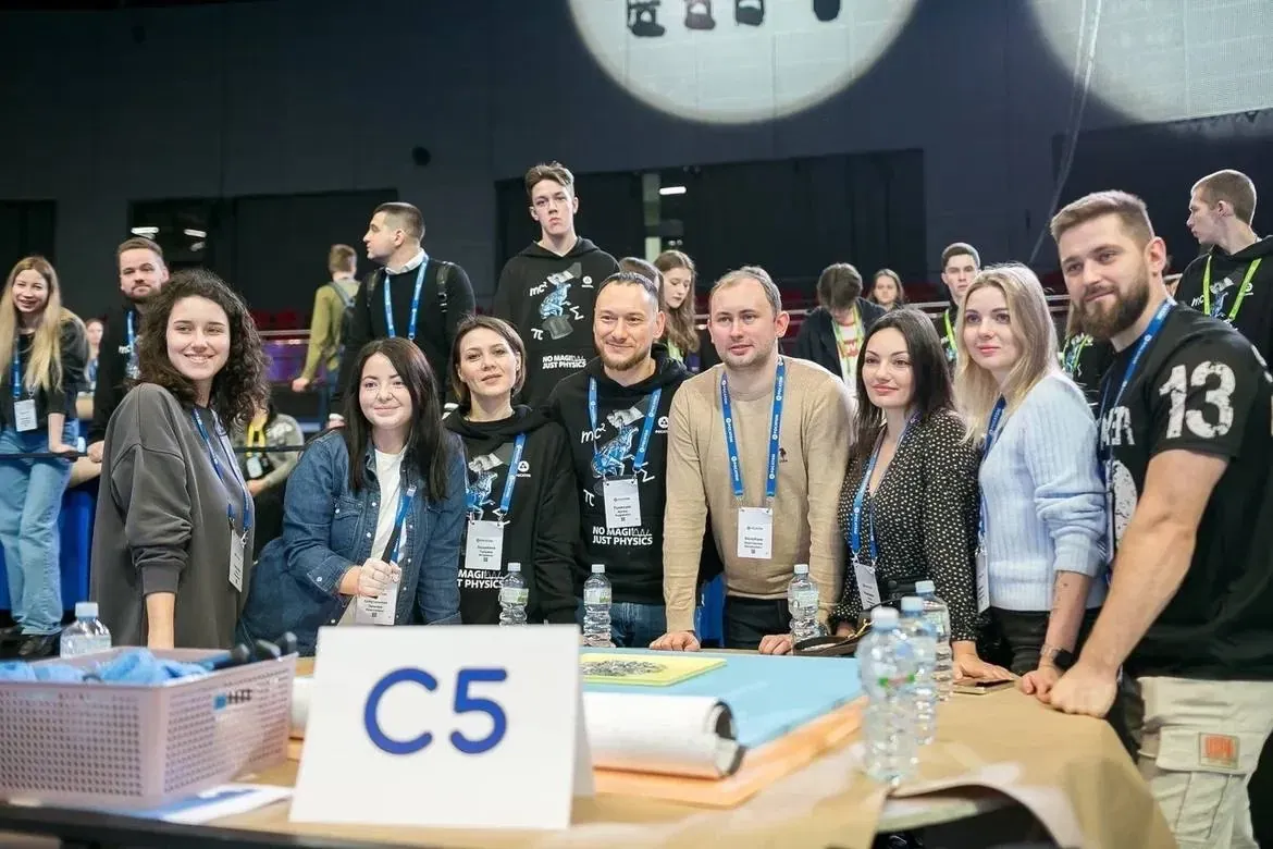 Команда за столом «C5», часть участников в худи коллекции